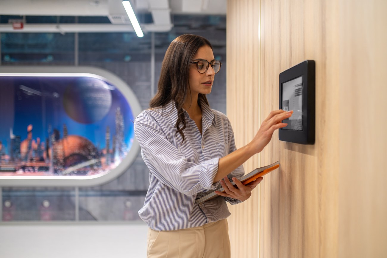 Employee checking in on a wall-mounted attendance panel